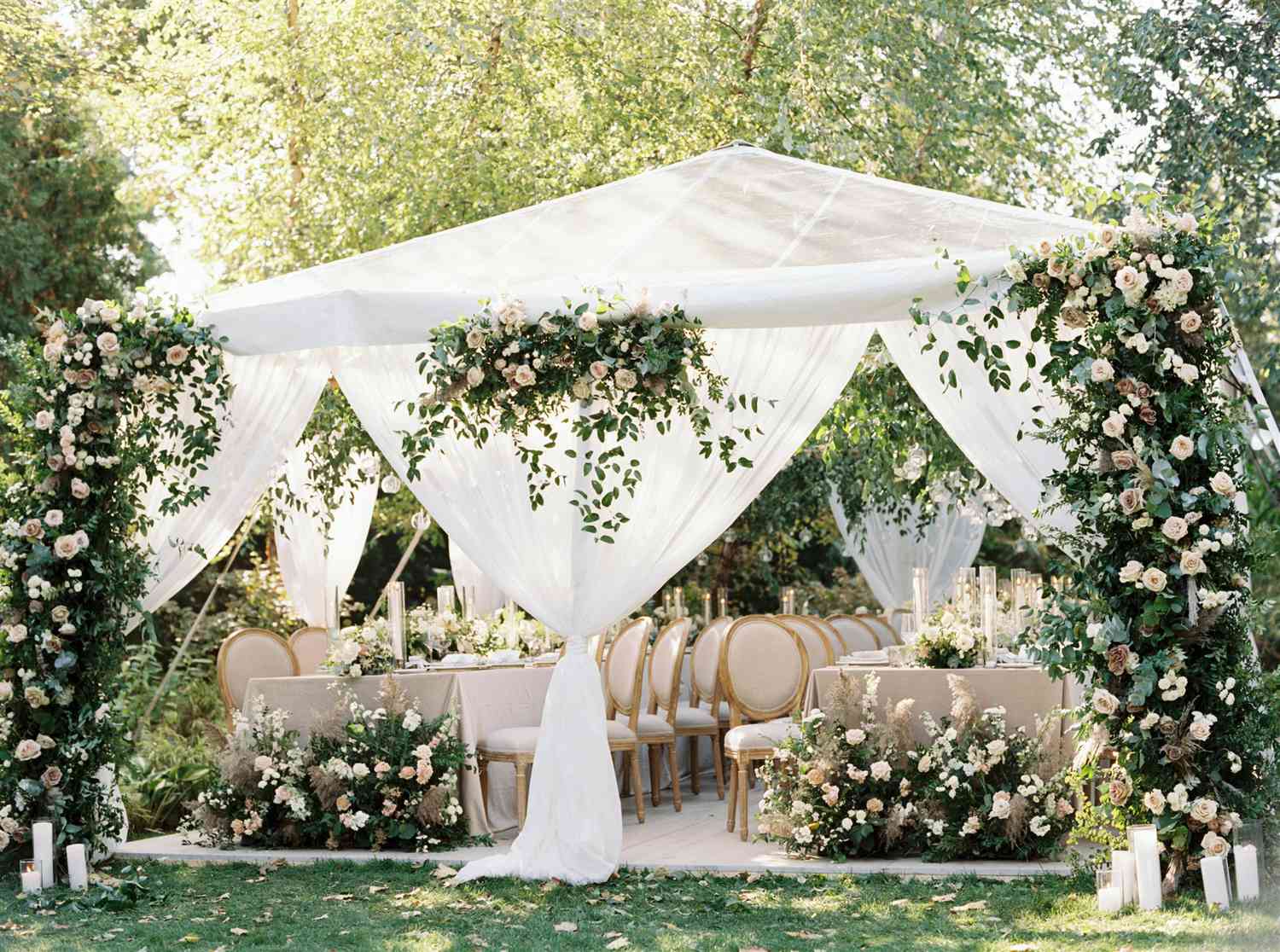 Gauzy wedding reception tent with florals at the entrance at backyard wedding