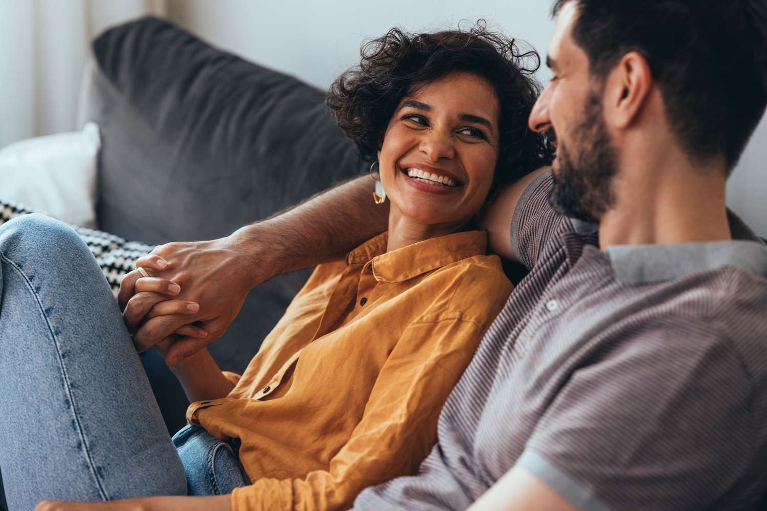 Woman and man sitting on the couch and smiling at each other