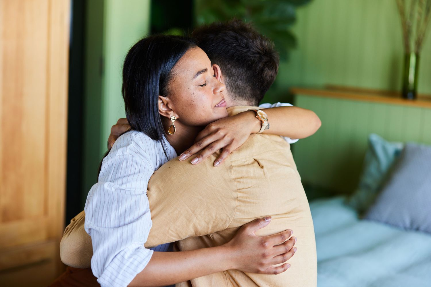 Man and woman hugging in bedroom