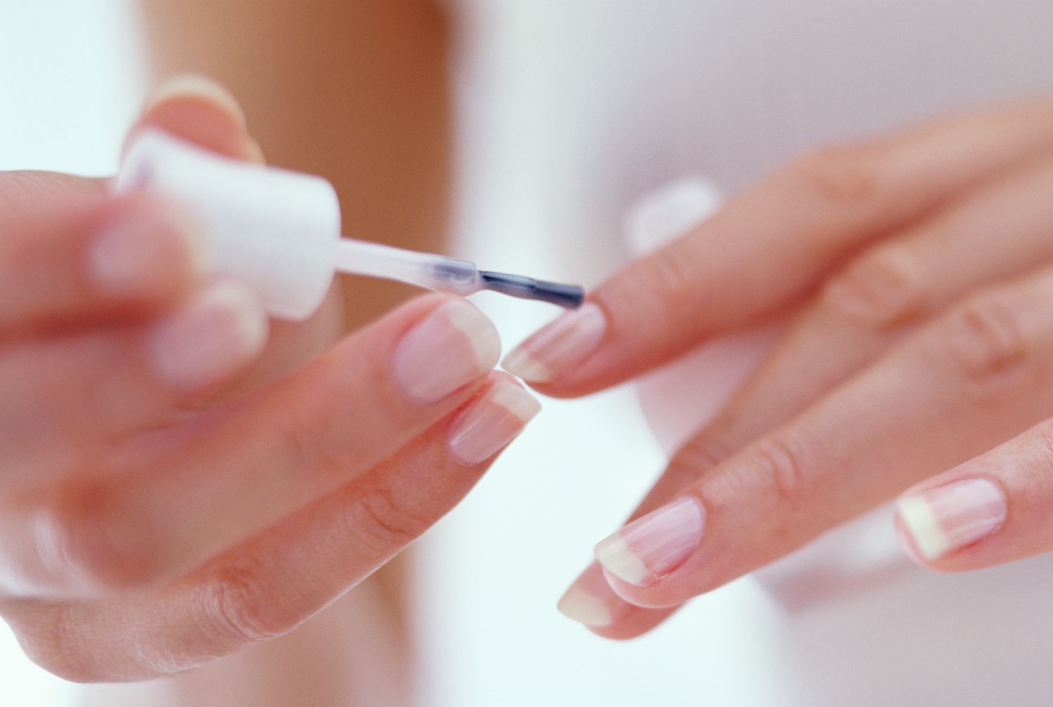 Woman painting her nails a French manicure