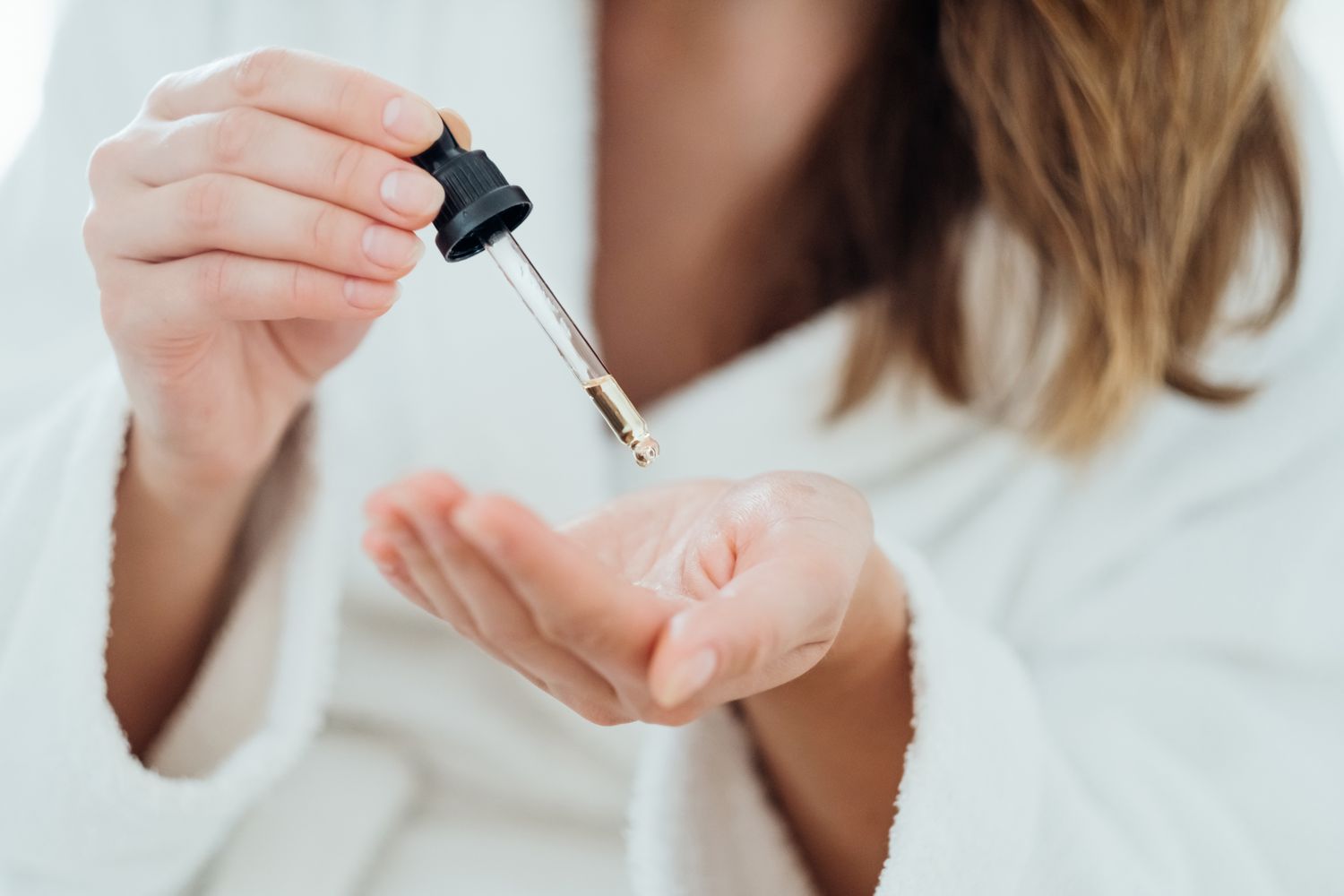 Woman holding serum dropper