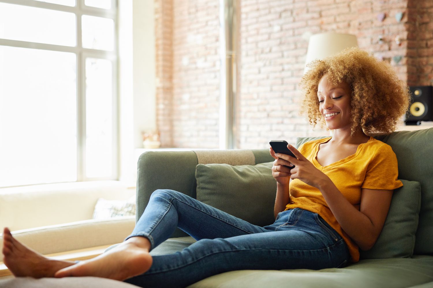 Woman sitting on the couch and texting