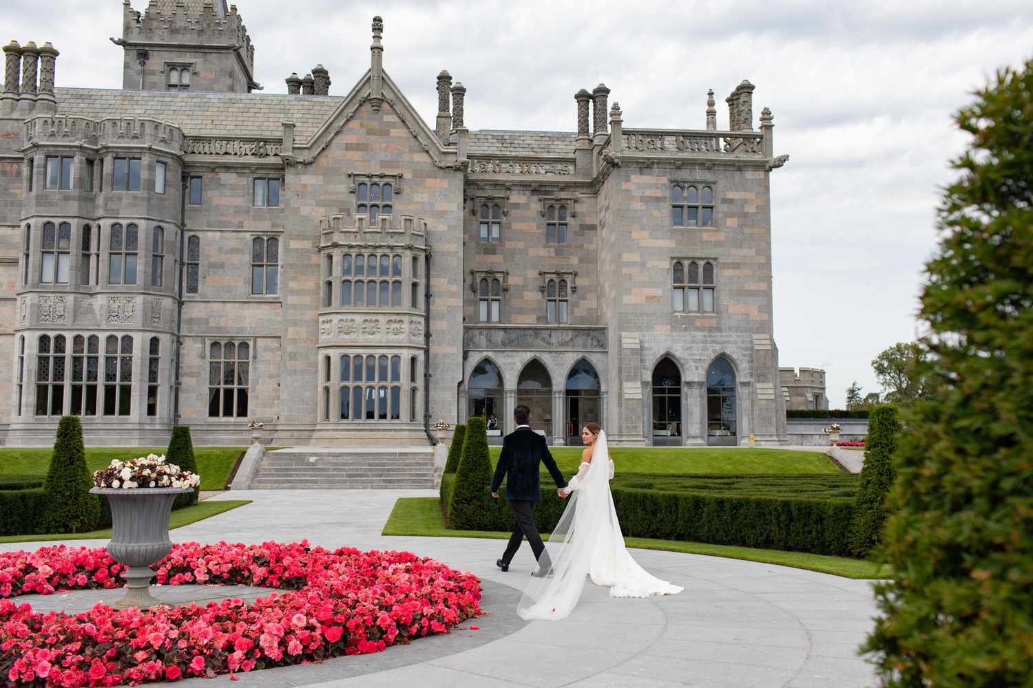 Bride and Groom Holds Hands as They Walk Outside of a Castle at Their Ireland Destination Wedding