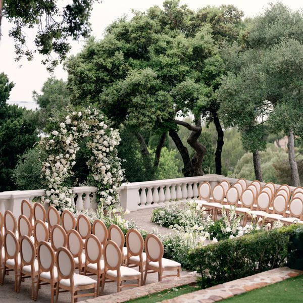 Outdoor Wedding Ceremony With White and Green Floral Ceremony Structure