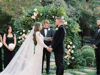 Bride and Groom Holding Hands While Exchanging Wedding Vows at Outdoor Wedding Ceremony