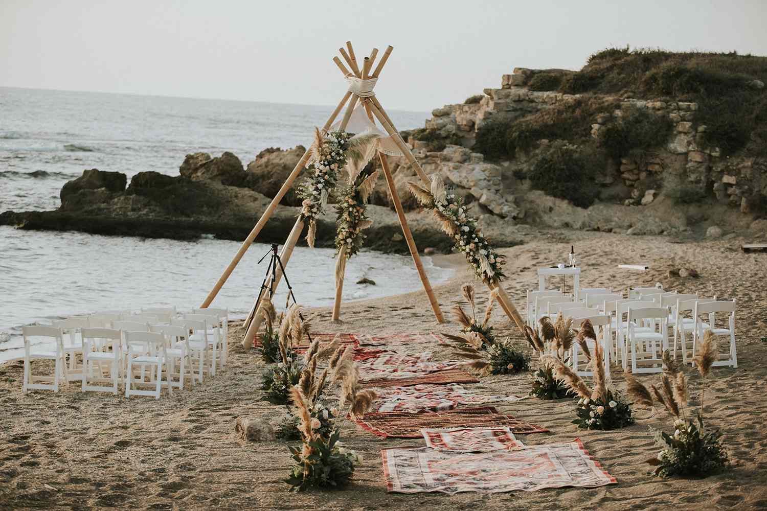 a nontraditional pyramid/tent-designed chuppah on the sand in Israel