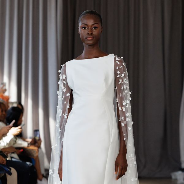 Model wearing a bateau-neck wedding dress with tulle sleeves