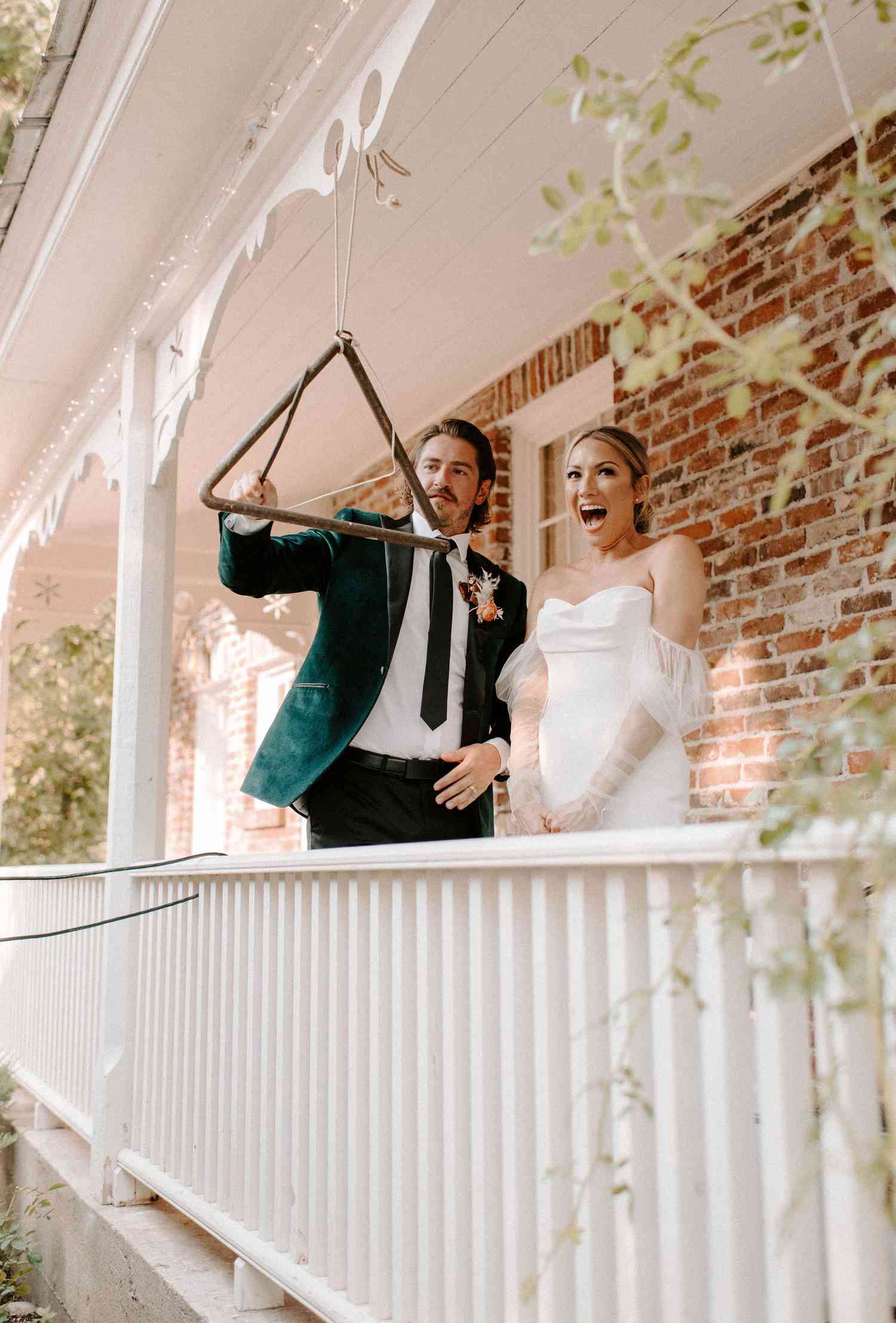 Bride and groom ringing a bell on a porch for their wedding entrance