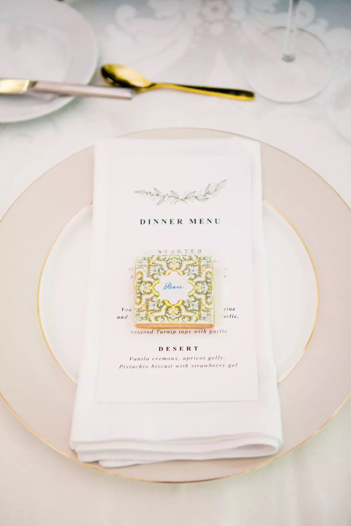 Place setting with pink charger, illustrated menu, and tile-inspired cookie