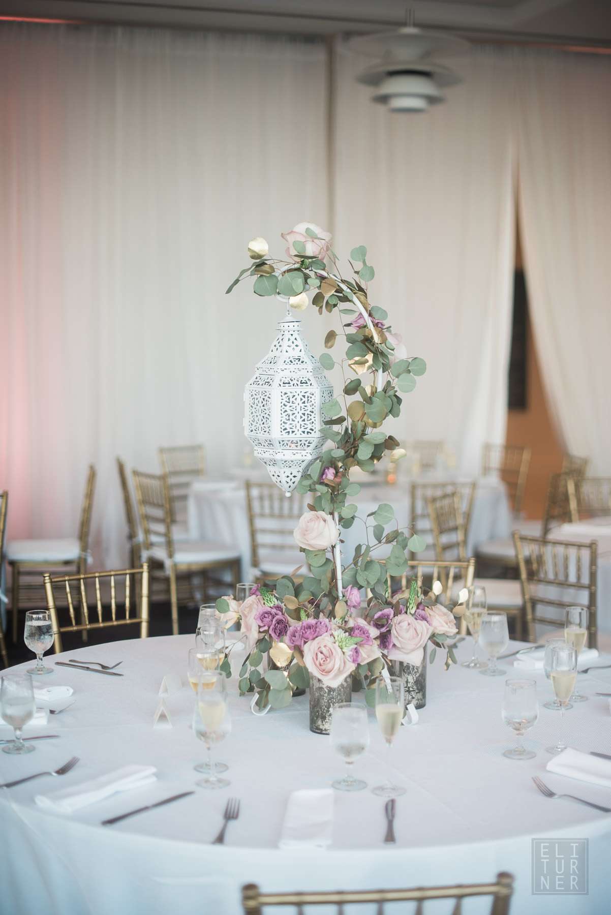 hanging lantern decorated with eucalyptus and purple flowers