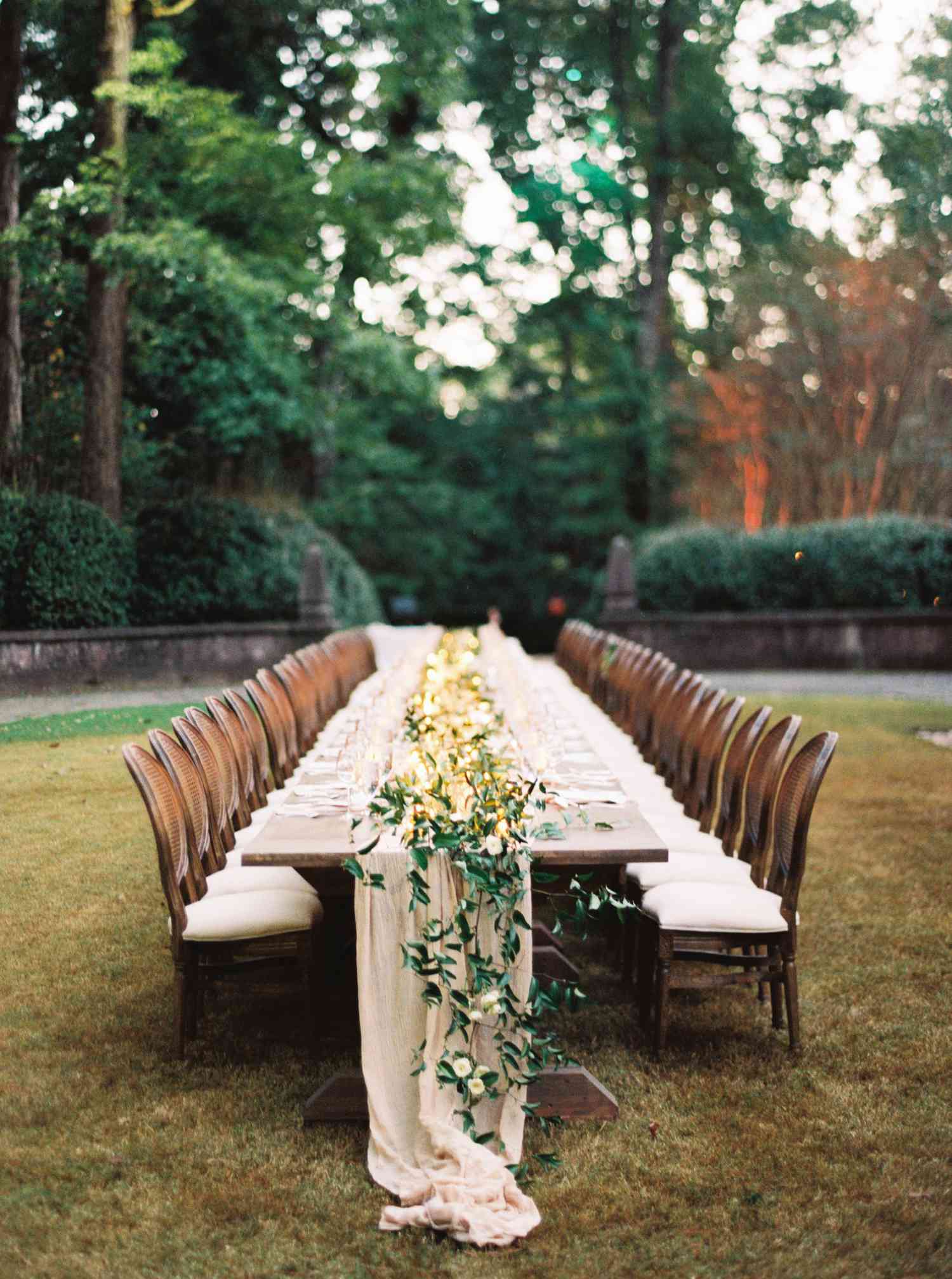 lights and greenery table centerpiece with ivy and wooden table in outdoor setting