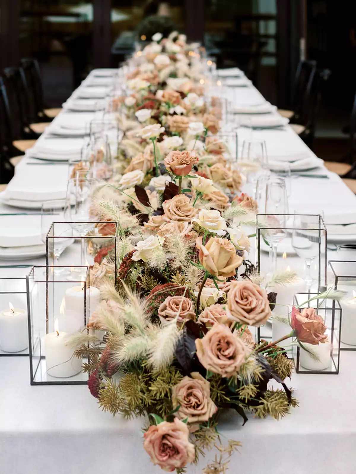 lanterns framing floral centerpiece runner in cream and pink tones