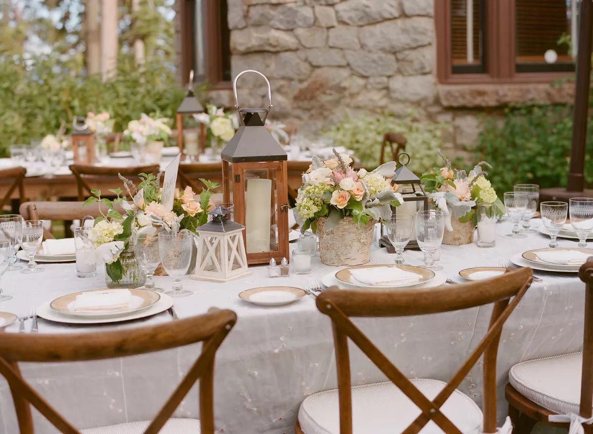 wooden lanterns on a runner with baskets of flowers