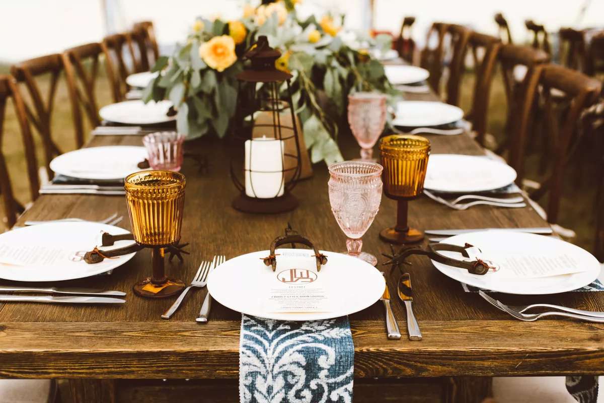 rustic brown lantern with vintage colored glasses on wood table