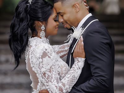 bride wearing high wedding ponytail hairstyle and posing for portrait with groom