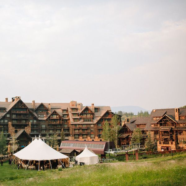 A white wedding tent outside of a Colorado ski resort near the ski lift and ski mountain in the summertime.