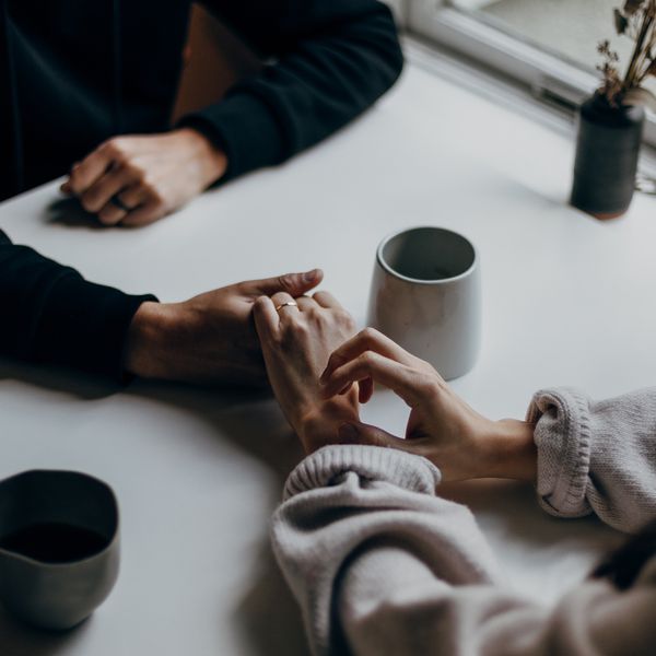 Couple Holds Hands Over the Table