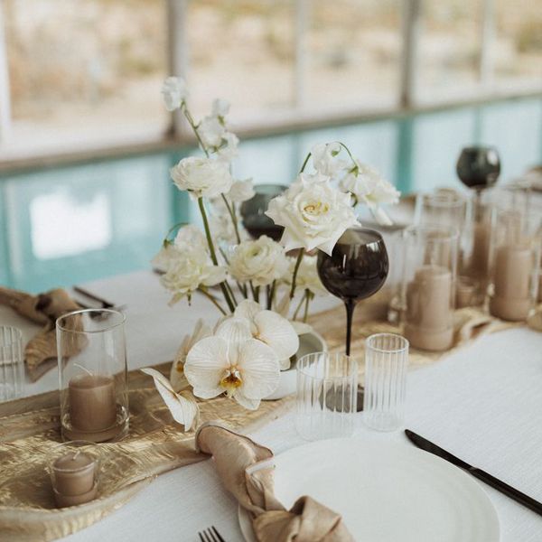 A white orchid centerpiece with white roses at a wedding.