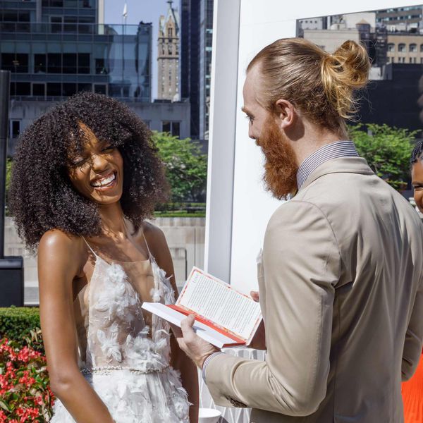 groom reciting vows at vow renewal ceremony as bride laughs