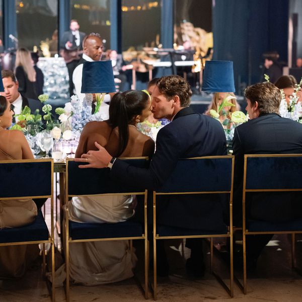 Couple Shares a Kiss While Seated at Their Dinner Table During Their Wedding Reception