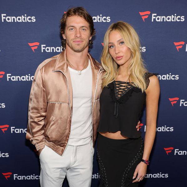 Braxton Berrios in White Getup and Alix Earle in All-Black Outfit Posing on Blue Carpet