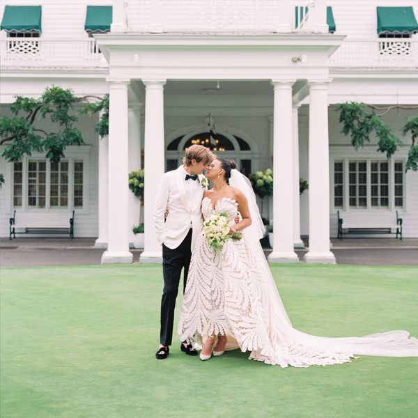 Bride In Strapless Applique Wedding Dress Posing With Groom in Black and White Tuxedo