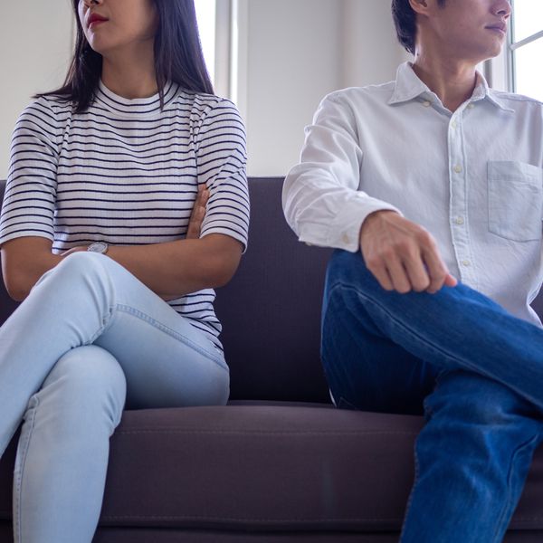 Man and Woman Sitting on Couch and Facing Opposite Direction From Each Other