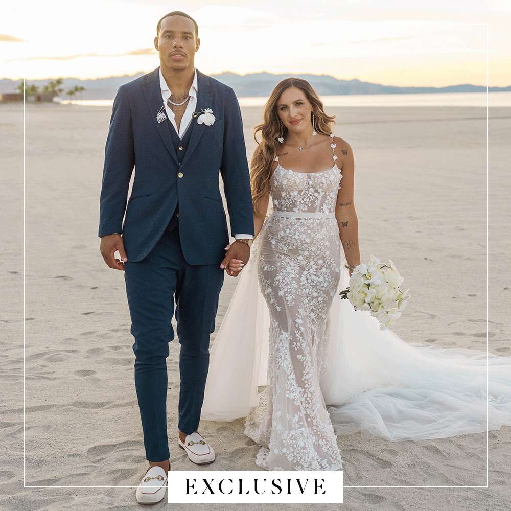 Desmond Bane in Navy Suit Posing With Tatum Bane in Lace Wedding Dress on Beach