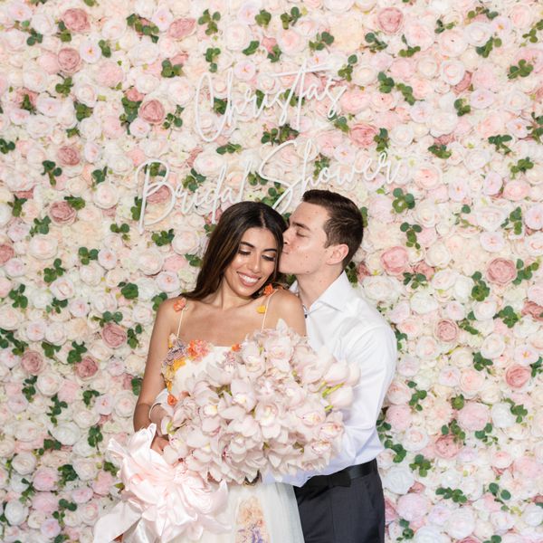 Christa's bridal shower photo wall with the bride and her fiancé