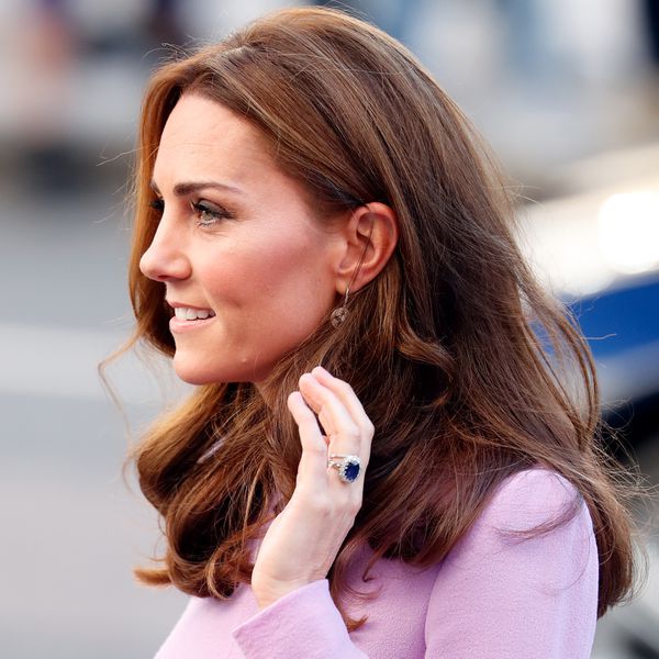Kate Middleton’s Side Profile With Pink Dress and Curled Hair and Holding Up Sapphire and Diamond Engagement Ring
