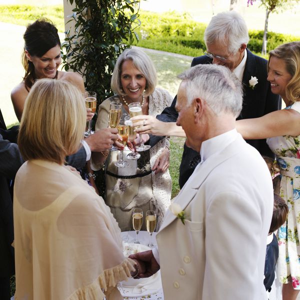 Group of Wedding Guests Holding Glasses of Champagne in Circle