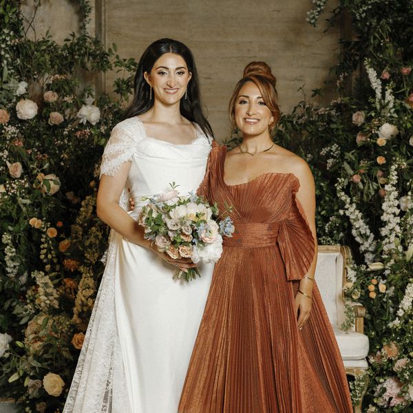 Bride in Wedding Dress and Lace Cape With Mother of the Bride in Orange Pleated Dress