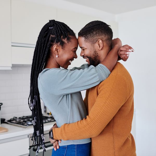 Smiling Couple Embracing One Another and Touching Foreheads in Kitchen