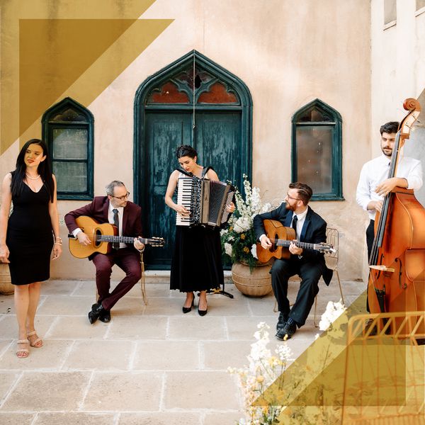 A five-piece live band performs at a wedding in an outdoor reception area.