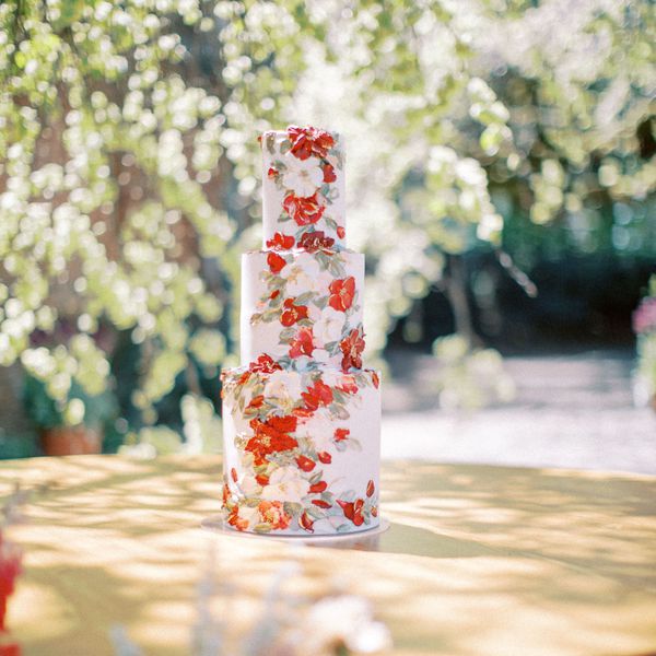 tiered wedding cake with red painted buttercream flowers