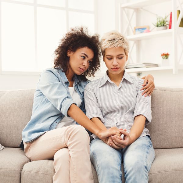 Two sad women talking at home