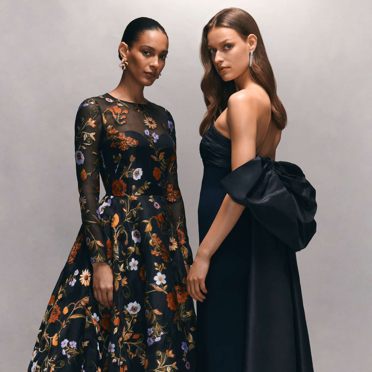 two models posing in black formal gowns