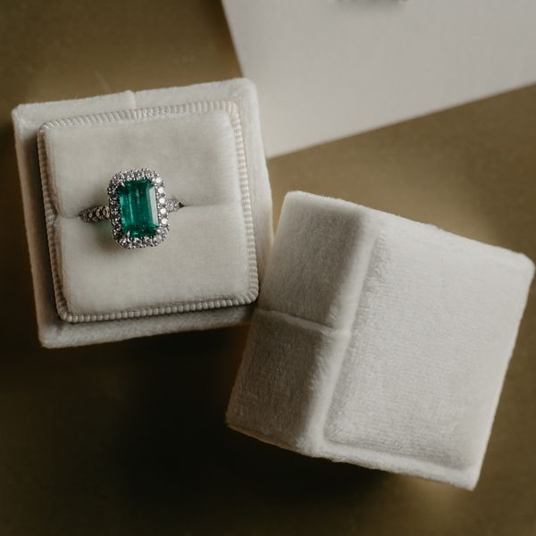 green engagement ring with a halo of white diamonds