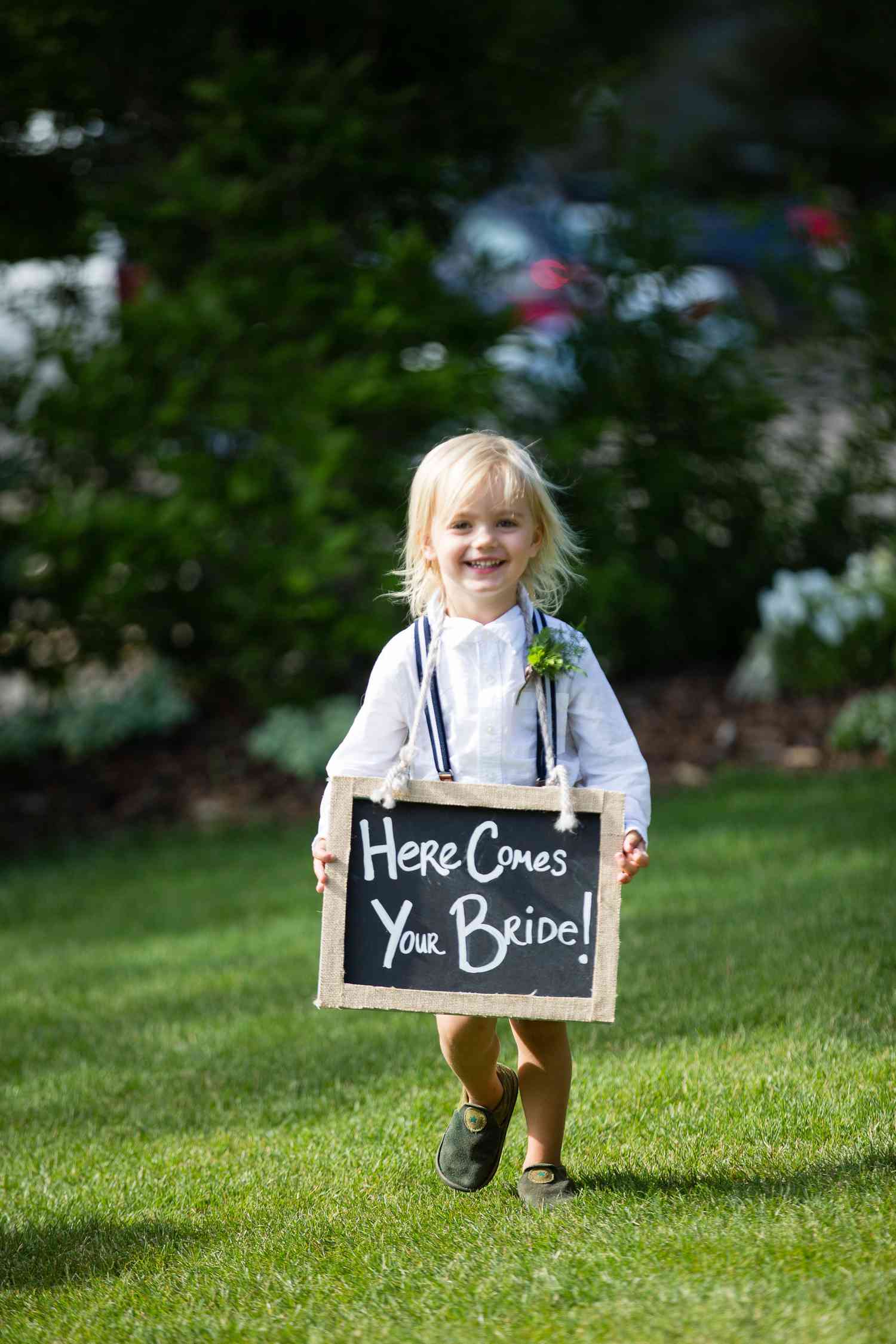 Ring Bearer Holding Chalkboard Sign at Outdoor Wedding Ceremony