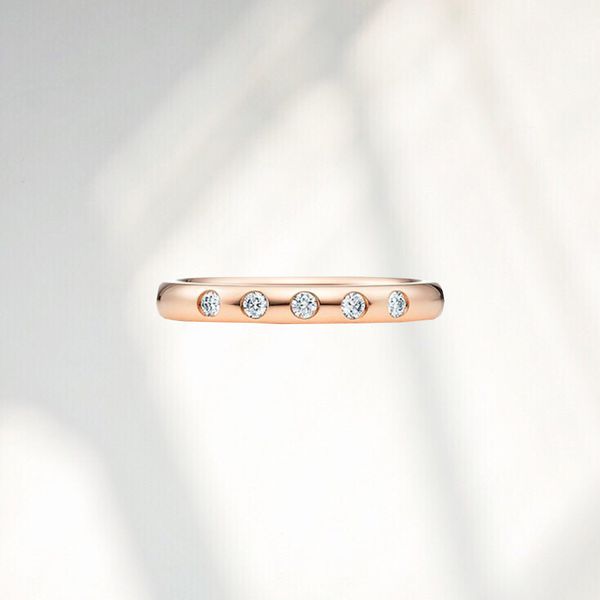 Collage of the Elsa Peretti Stacking Band Ring on a gray background