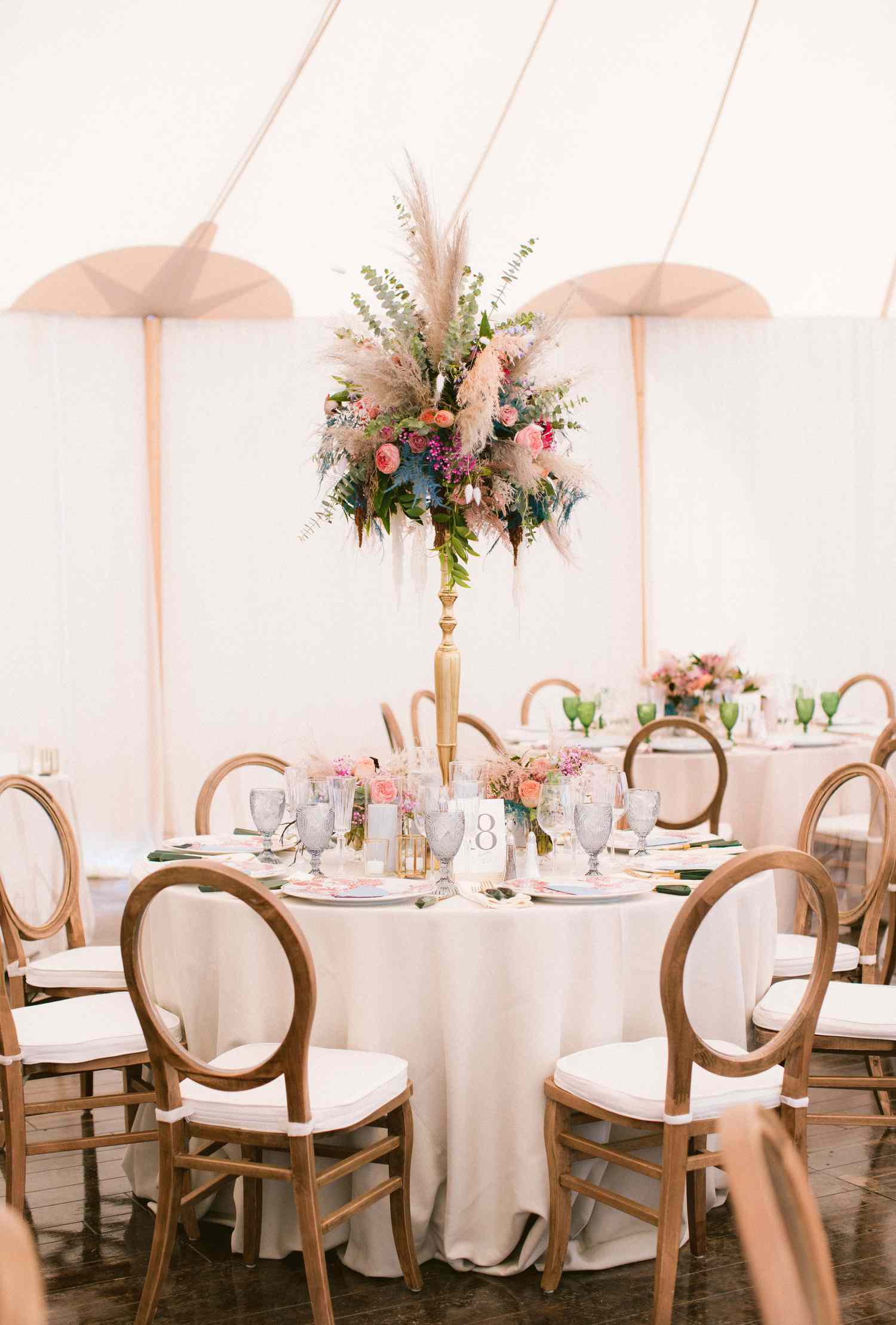 Tall Floral Centerpiece in the Middle of Round Wedding Reception Table