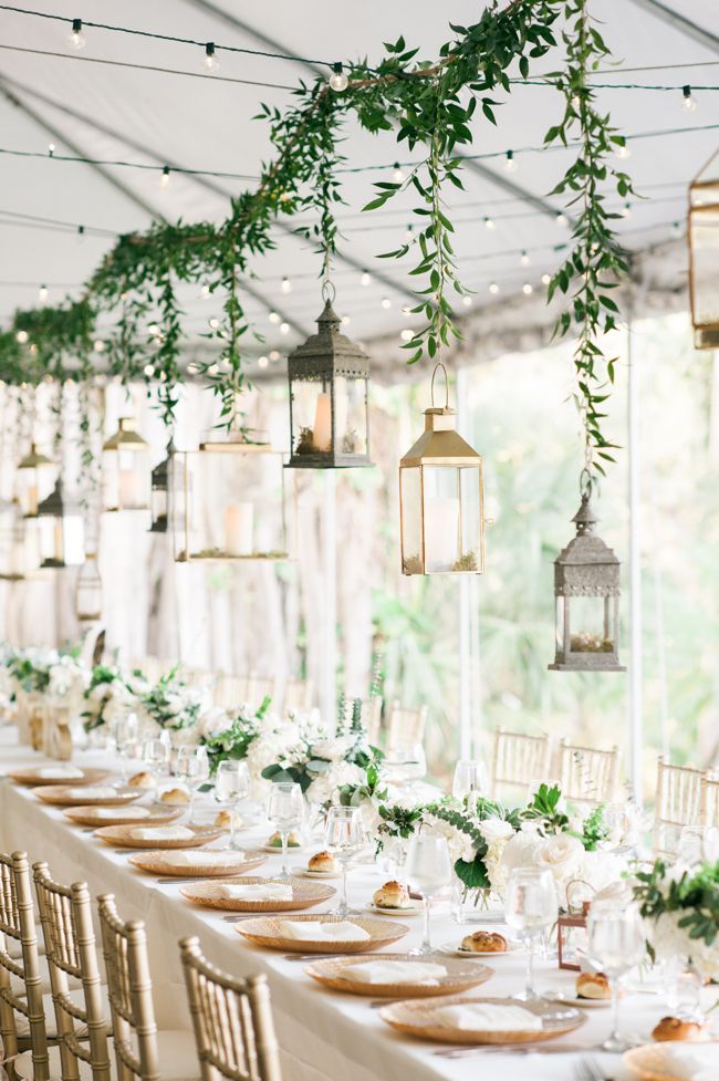 hanging lanterns in silver and gold suspended overhead with greenery
