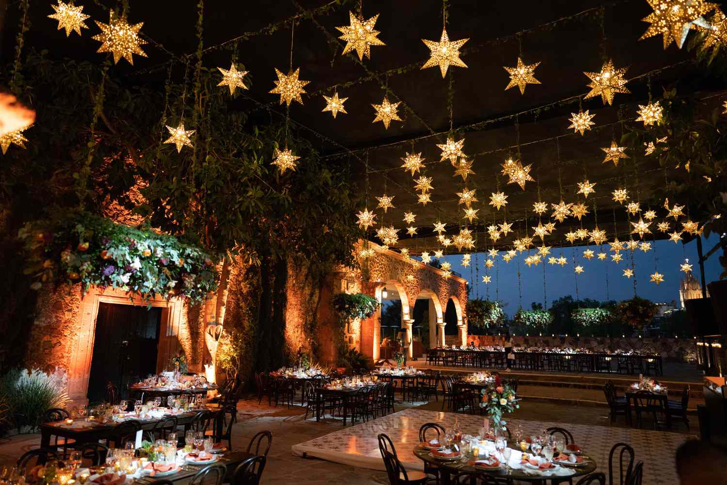 A wedding reception space with star lights suspended above the tables
