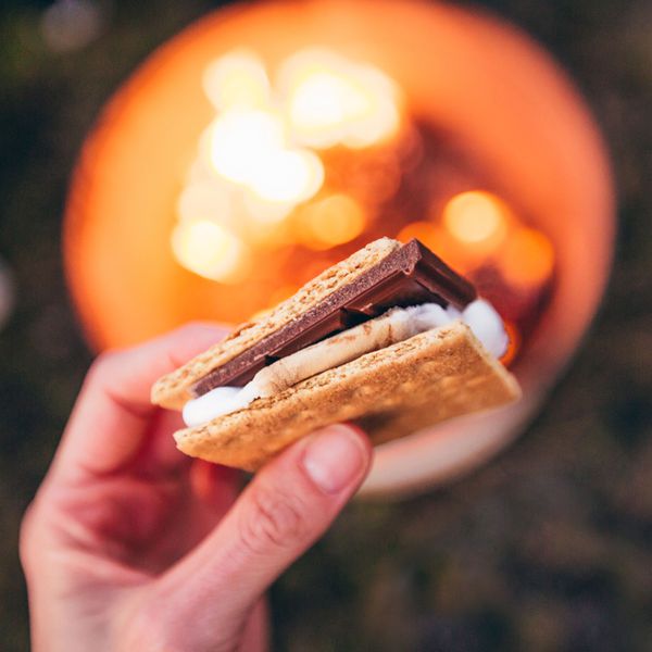Person Holds a S'more From a S'mores Bar at a Wedding