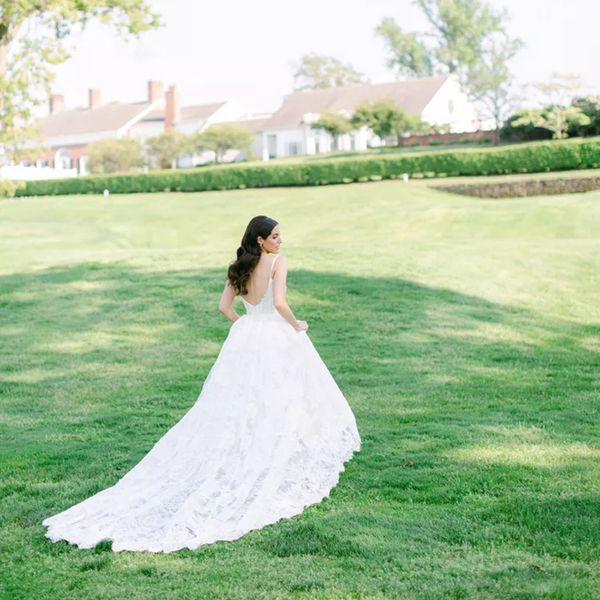 Bride with long wavy hair wearing Monique Lhuillier Wedding Dress Outside