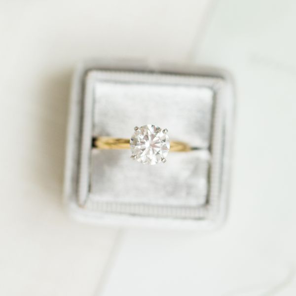 gold solitaire round diamond ring in a grey ring box
