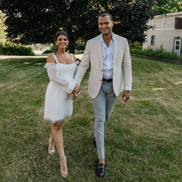Couple Holding Hands and Walking on Lawn in Dress Clothes