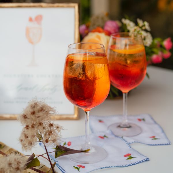 two Aperol spritzes on a bar
