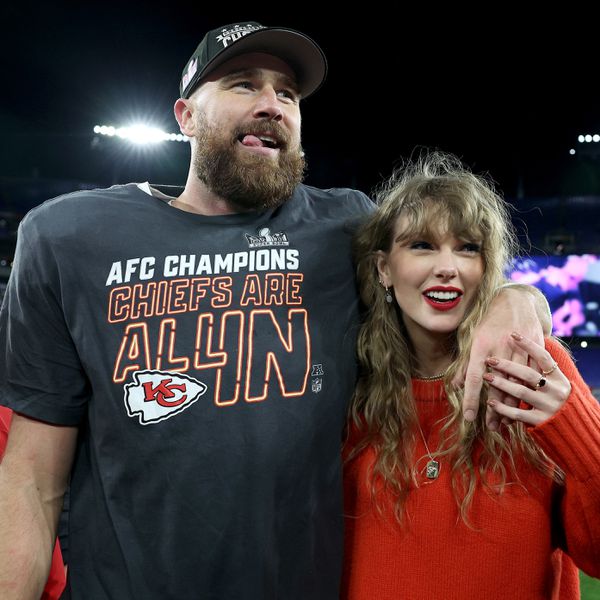 Taylor Swift and Travis Kelce with arms around one another on football field