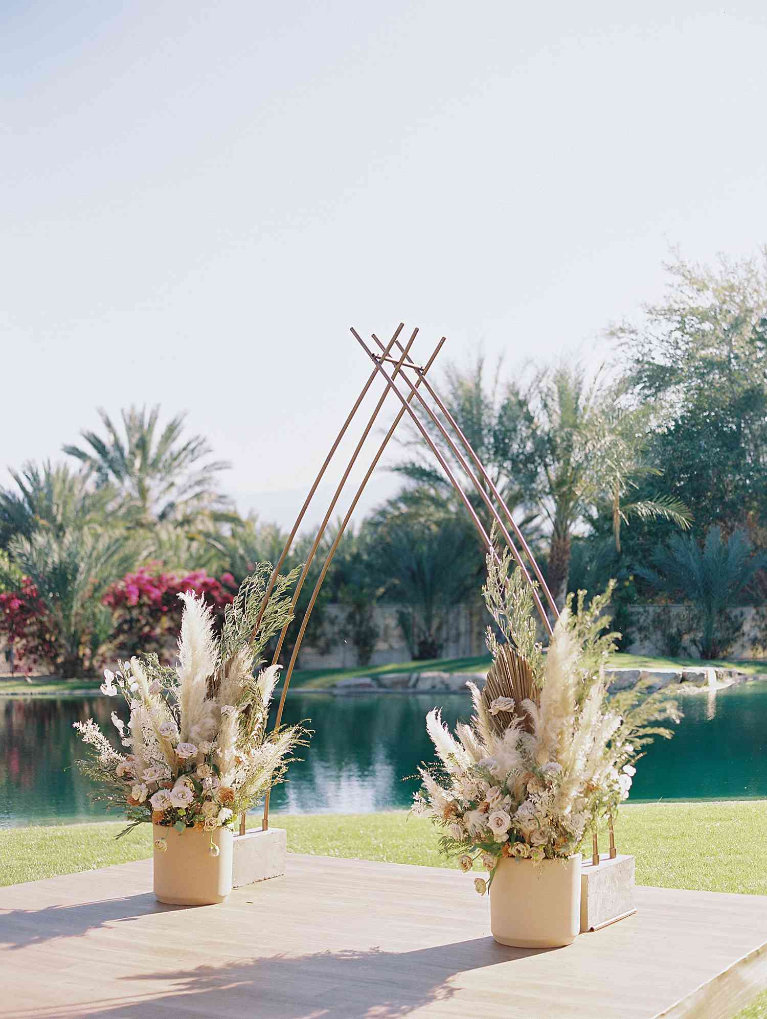 Tiffany and Michael's ceremony altar flanked by arrangements with pampas grass and dried palm leaves